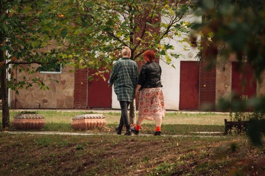 Young beautiful loving stylish lesbian couple hugging each other and have a nice day in the autumn park. Season, beauty, love concept