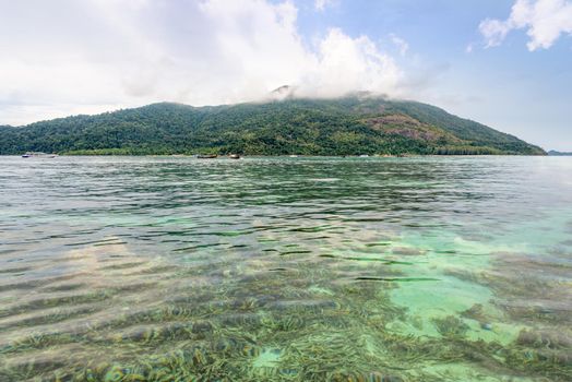 Beautiful nature landscape clear green sea water overlook the shallow coral reefs of Koh Lipe island, see Ko Adang island as a background at blue sky summer, Tarutao National Park, Satun, Thailand