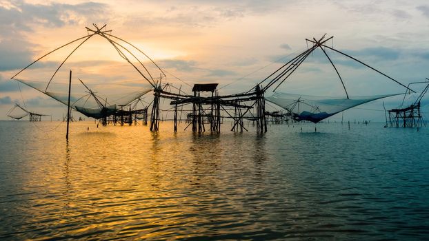 Beautiful nature landscape golden light of the morning sky at sunrise and native fishing tool rural lifestyle at Pakpra canal in Songkhla Lake, Baan Pak Pra, Phatthalung, Thailand,16:9 widescreen