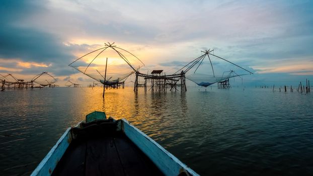 Beautiful nature landscape golden light of the morning sky at sunrise and native fishing tool and prow rural lifestyle at Pakpra canal Songkhla Lake, Baan Pak Pra, Phatthalung,Thailand,16:9 widescreen