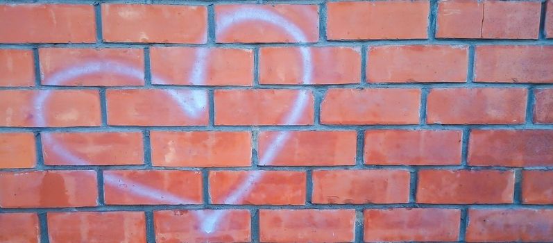 Red brick wall with white heart-shaped outlines.