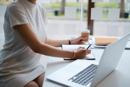 Business woman concentrates on a webinar on her laptop computer