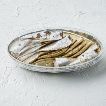 Canned Anchovies set, in plastic container, on white background