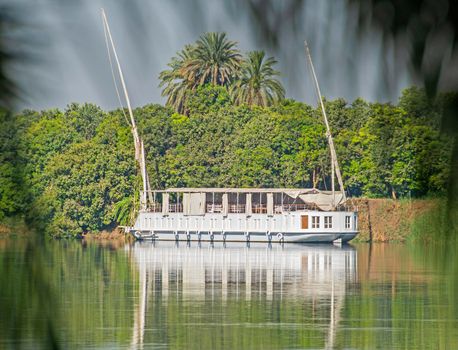 Large luxury traditional Egyptian dahabeya river cruise boat moored on the Nile bank