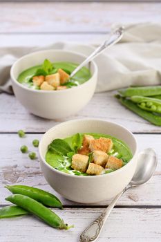 Chilled soup puree of green peas,  seasoned with green onion, mint and crunchy  toasted diced rusk bread  