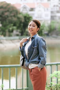 Portrait of young stylish woman walking on the street, wearing cute trendy outfit, smiling enjoy her weekends, travel with backpack