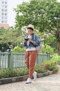 Charming female photographer taking photos during city walk, copy space