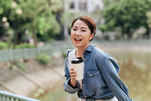 Woman Relaxing in Park With Takeaway Coffee