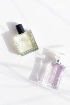 Perfume on a white background with shadows . The choice of perfume. Aromatherapy. Smell. A bottle of perfume. White background. Light and shadows . Copy space