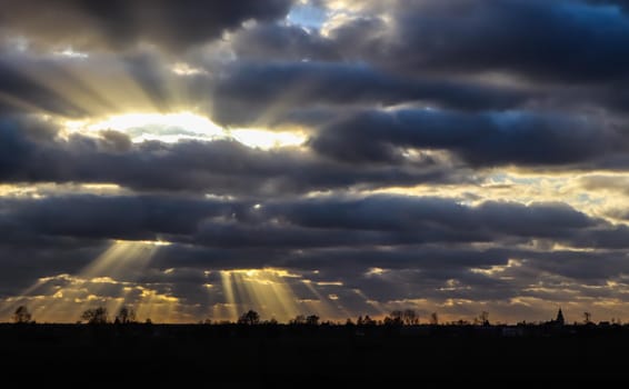 Blue sky and dark clouds with sunlight