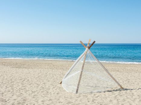 Fishing net is drying on a sandy mediterranean sea beach on a bright sunny day