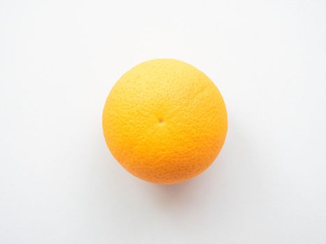 Ripe orange on a light gray surface. Top view, not isolated