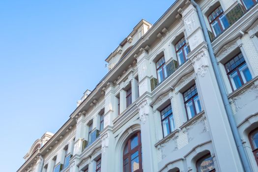 Beautiful facade of an old building with lots of windows, against a blue sky