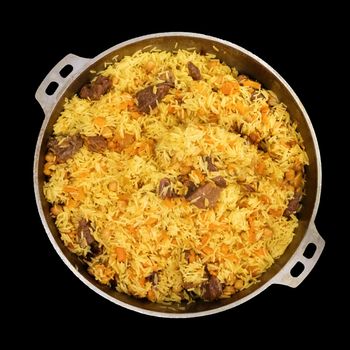 Rice pilaf in a large pan isolated on black. Eastern cuisine. Top view