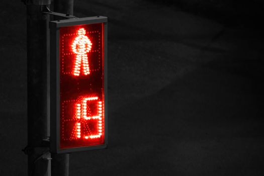 Stop COVID-19 lockdown conceptual image. Red pedestrian traffic light signal on dark night black-n-white background