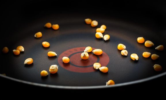 Corn grains in a frying pan. Dark moody style. Horizontal image.