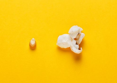 Corn grain and popcorn on yellow background. Concept of evolution and growth. Horizontal image. Top view.