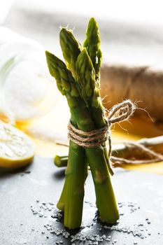 Asparagus. Bunch of fresh wild asparagus standing on a slate plate. Healthy vegetarian food. Vertical image