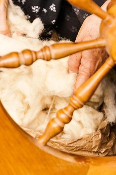 Oldster spinning cotton of traditional form on a craftsmen's market.