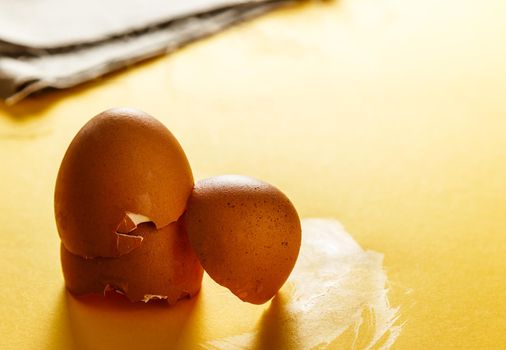 Eggshells on a yellow surface and a piece of sackcloth in the background. Close-up view Food for a healthy life. Horizontal image.