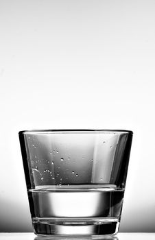 Black and white glass of water with white background. Black and white.