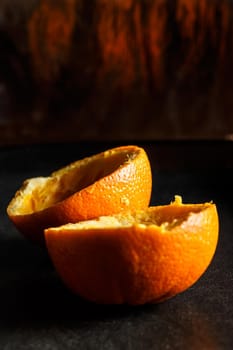 Used orange skins with dramatic light on black background. Vertical image.