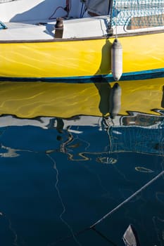 Pleasure boat with reflections in the water in the marina.