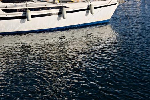 Pleasure boat with reflections in the water in the marina.