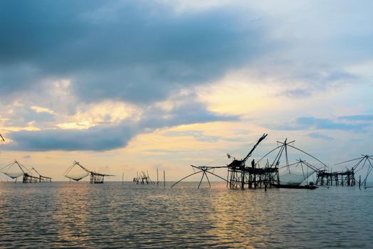 Beautiful nature landscape of Songkhla Lake at sunrise and fisherman are using bamboo and net as native fishing tool to catch fish rural lifestyle at Pakpra canal, Baan Pak Pra, Phatthalung, Thailand