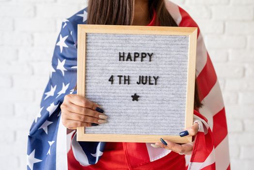 Independence day of the USA. Happy July 4th. Woman with american flag holding letter board with words Happy 4th July