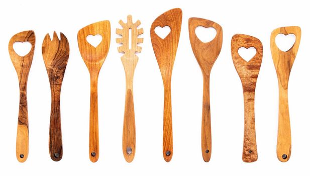 Various heart shape of wooden cooking utensils. Wooden spoons and wooden spatula isolate on white background.