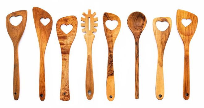 Various heart shape of wooden cooking utensils. Wooden spoons and wooden spatula isolate on white background.