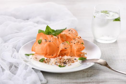 Gluten free vegetarian salad with carrot and yogurt seasoned with crushed nuts and spices, mint castings