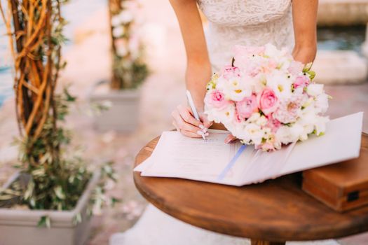 Newlyweds put their signatures in the act of registering a marriage at a wedding ceremony in Montenegro.