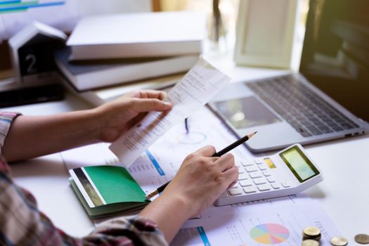 Accounting concept. Businesswoman using a calculator to calculate bill income expenditure, Savings account, business profits, control expenses.