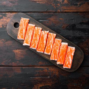 Fresh Crab meat surimi with blue swimming crab set, on wooden cutting board, on dark wooden background, top view flat lay