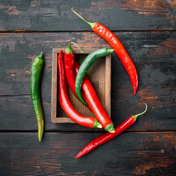 Red and green chili pepper set, in wooden box, on dark wooden background, top view flat lay