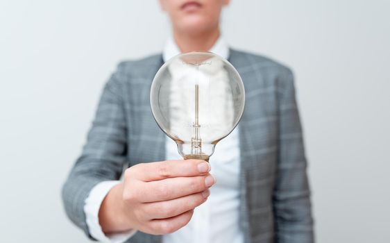 Lady Holding Lamp With Formal Outfit Presenting New Ideas For Project, Business Woman Showing Bulb With One Hand Exhibiting New Technologies, Lightbulb Presenting Another Openion.