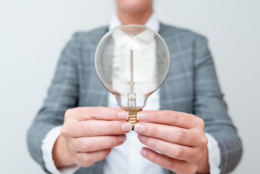 Lady Holding Lamp With Formal Outfit Presenting New Ideas For Project, Business Woman Showing Bulb With Two Hands Exhibiting New Technologies, Lightbulb Presenting Another Openion.