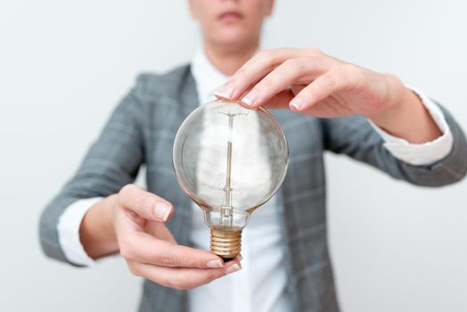 Lady Holding Lamp With Formal Outfit Presenting New Ideas For Project, Business Woman Showing Bulb With Two Hands Exhibiting New Technologies, Lightbulb Presenting Another Openion.