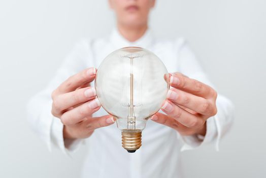 Lady Holding Lamp With Formal Outfit Presenting New Ideas For Project, Business Woman Showing Bulb With Two Hands Exhibiting New Technologies, Lightbulb Presenting Another Openion.