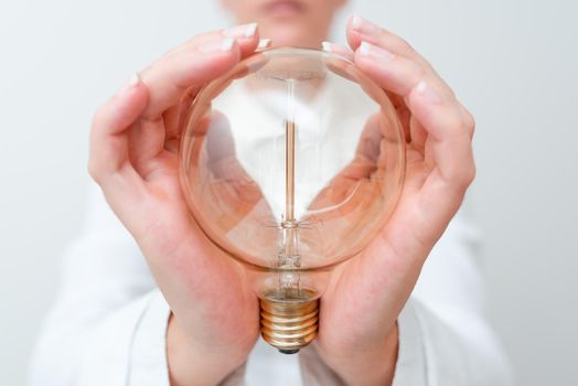 Lady Holding Lamp With Formal Outfit Presenting New Ideas For Project, Business Woman Showing Bulb With Two Hands Exhibiting New Technologies, Lightbulb Presenting Another Openion.