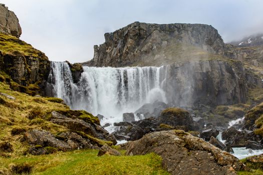 Waterfall in winter, Reyoarfjorour fjord, Iceland.