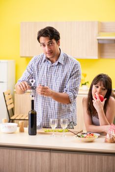 Young couple celebrating wedding anniversary at kitchen 