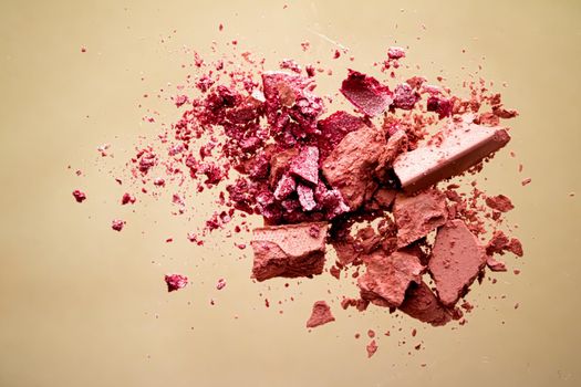 Crushed cosmetics, mineral organic eyeshadow, blush and cosmetic powder isolated on golden background, makeup and beauty banner, flatlay design.