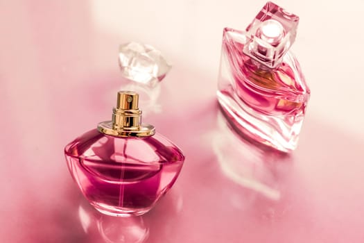 Perfumery, spa and branding concept - Pink perfume bottle on glossy background, sweet floral scent, glamour fragrance and eau de parfum as holiday gift and luxury beauty cosmetics brand design