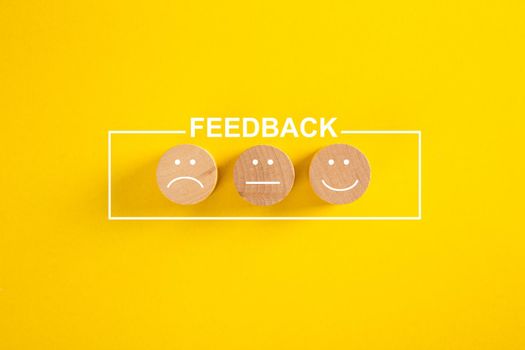 Customer feedback and satisfaction conceptual image - happy, sad and neutral faces over yellow background