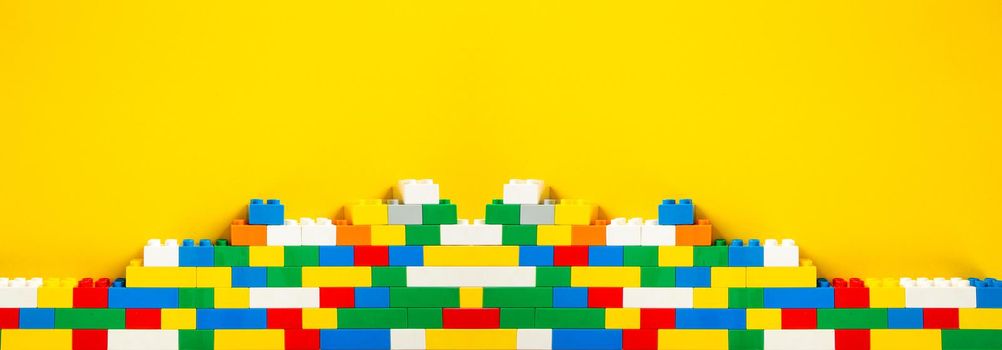 Plastic building blocks on yellow background