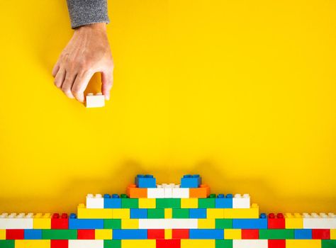 hand stacking up the colorful plastic block