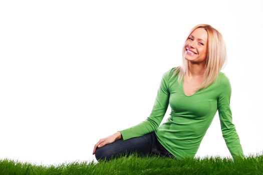 Young beautiful woman sitting on grass, isolated on white background